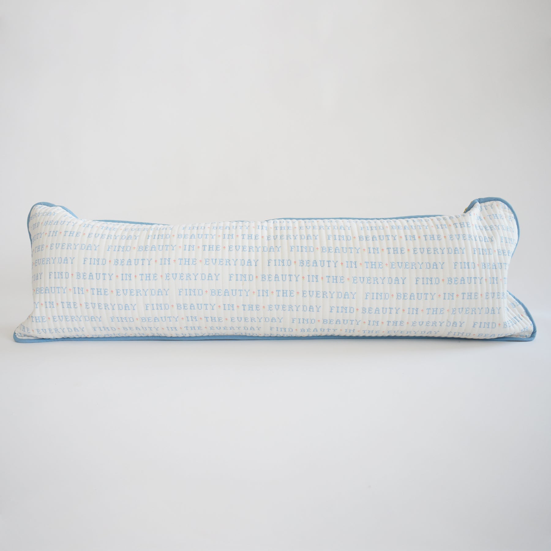 The Sara Fitz Lumbar Pillow, Cross Stitch Floral, features a long, rectangular cotton cover with a floral cross-stitch design and includes a plush down alternative insert for comfort.