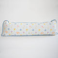 The Sara Fitz Lumbar Pillow, Cross Stitch Floral, is a long, rectangular cotton quilted pillow made in India with a white background, blue edging, and a grid of colorful floral and small motif designs.