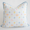 The Sara Fitz Oversized Pillow, Cross Stitch Floral, features a white cotton quilted cover with pastel floral and diamond patterns, light blue piping, a small round tag, down alternative insert, and is made in India.