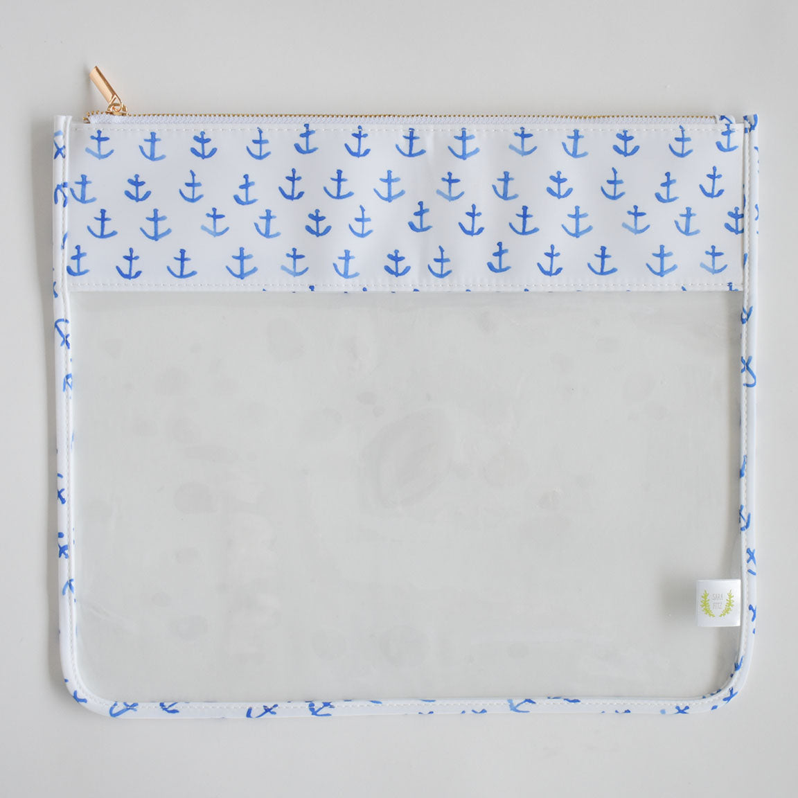 Introducing the Sara Fitz Anchor Project Bag: this oversized pouch features a striking white and blue anchor pattern at the top, complemented by blue trim and a zipper closure. The bottom section is fully transparent—perfect for displaying your supplies—while a small white tag accents the bottom right corner. Crafted from heavyweight canvas with signature Sara Fitz prints, this durable project bag effortlessly blends stylish design with practical function.