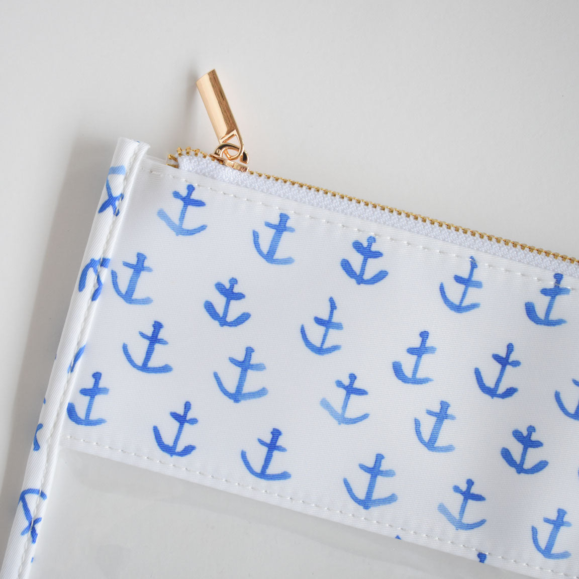 The Sara Fitz Anchor Project Bag is a white heavyweight canvas pouch featuring a gold zipper and an allover print of light blue anchors inspired by classic Sara Fitz designs. Shown against a simple, light background, this spacious zippered bag is ideal for organizing oversized projects or keeping your everyday essentials handy.