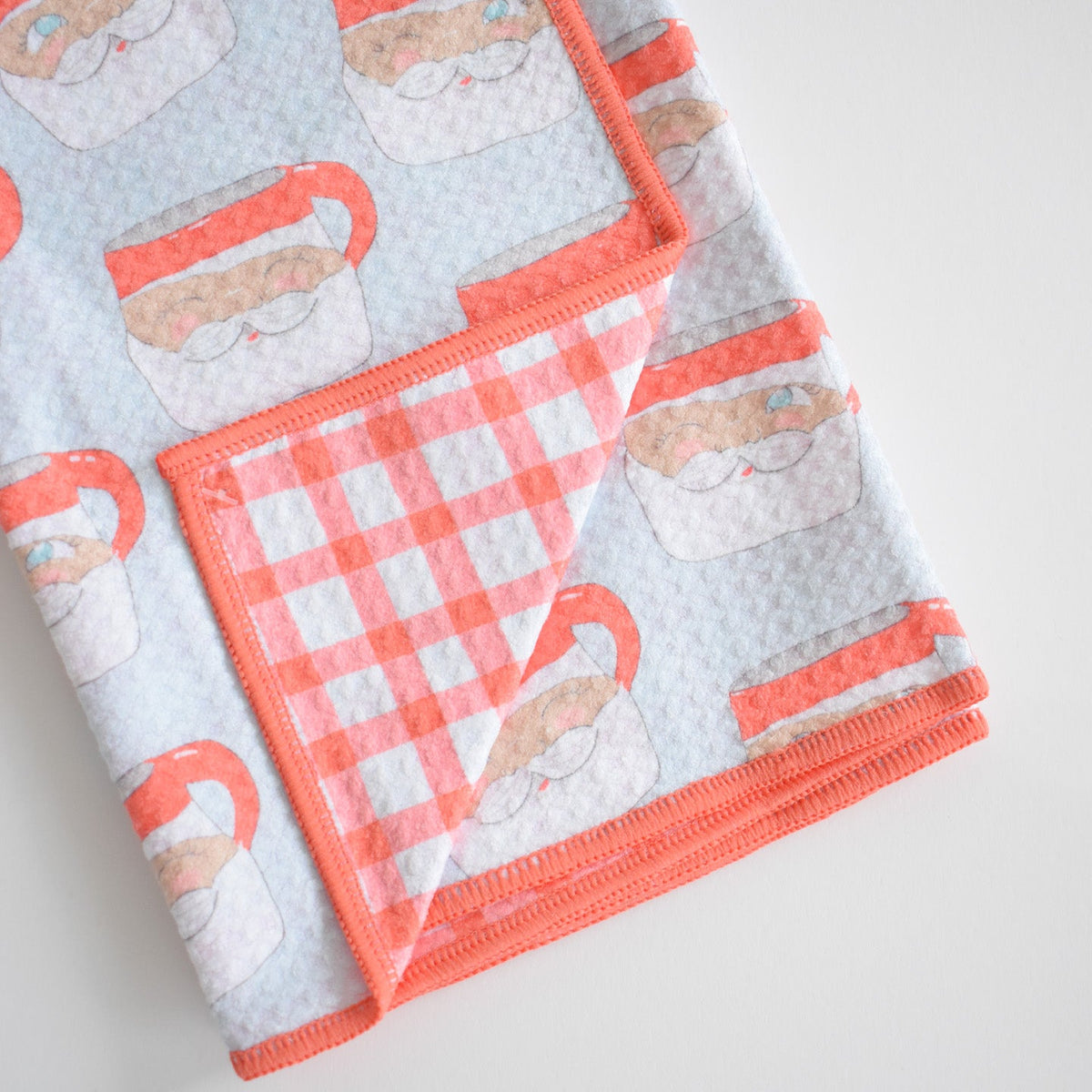 Sara Fitz Anywhere Towel, Santa Mug, featuring a Santa mug pattern on one side and a red and white checkered pattern on the reverse.