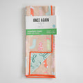 Sara Fitz Anywhere Towel, Stockings, folded and secured by a paper band displaying branding and product information on the absorbent fabric.