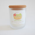 Hand-poured in Maine, the Sara Fitz Cider Season Candle comes in a frosted glass jar with a cork lid. The label reads “SARA FITZ CIDER SEASON” and displays an illustration of a basket holding an apple and a pear. Crafted from coconut soy wax, this apple cinnamon candle features scent notes of apple, cinnamon, nutmeg, and vanilla.