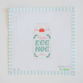 The Eggnog Needlepoint by Sara Fitz features a carton labeled Organic Egg Nog with floral accents, bordered by blue and white stripes on 18 mesh canvas. "Sara Fitz" and other small text appear in the lower corners.