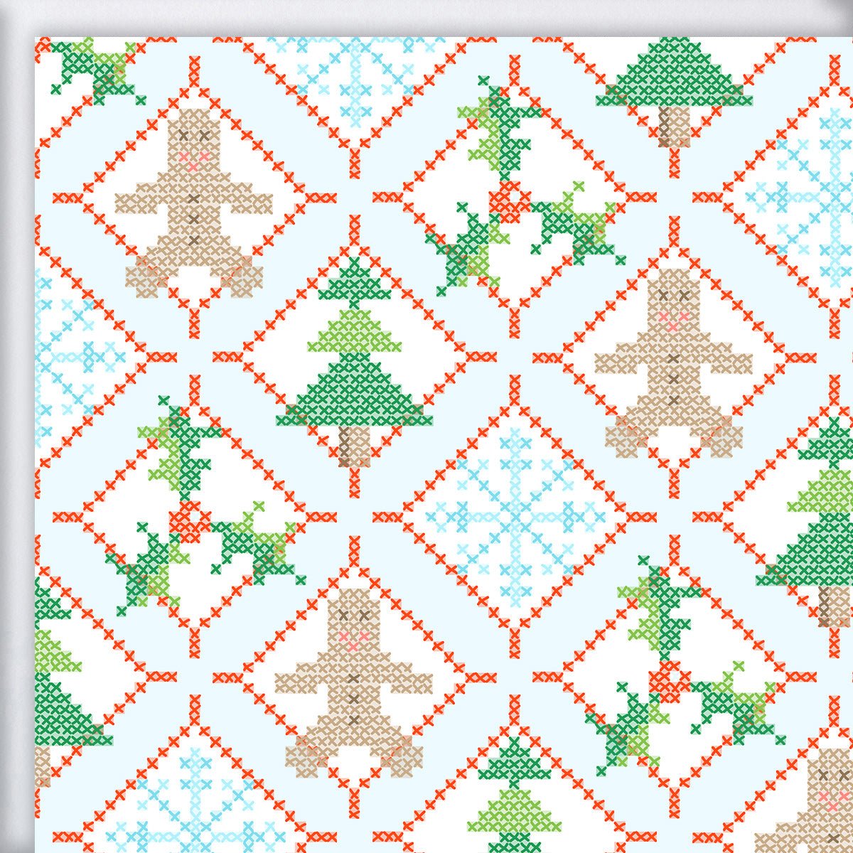 Holiday Cross Stitch Gift Wrap featuring a repeating cross-stitch pattern of gingerbread men, Christmas trees, snowflakes, and holly within a red stitched diamond grid on a light blue background.