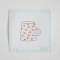 The Heart Mug Needlepoint by Sara Fitz is a stitch-painted cross-stitch pattern featuring a white coffee mug with a handle, adorned with small red hearts, on an 18 mesh canvas square bordered by light blue and white stripes.