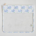 The Sara Fitz Hydrangea Project Bag is a clear plastic pouch with a white top border adorned with light blue hydrangea flowers and green leaves, featuring the charming Sara Fitz prints, a gold zipper closure, and a small fabric side tag.