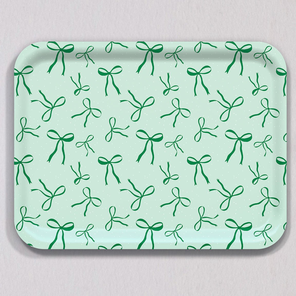 Large Green Bows Tray, a rectangular birch wood tray featuring a repeating pattern of green bows on a pale green background with white speckles.