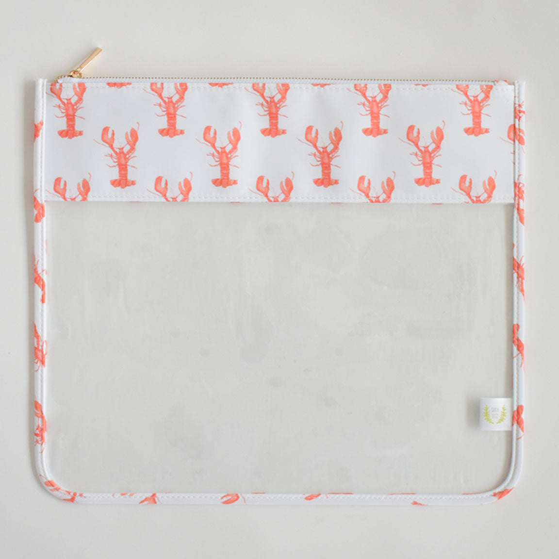 The Sara Fitz Lobster Project Bag is a rectangular clear pouch featuring a white top border adorned with a repeating orange lobster pattern and finished with a light-colored zipper closure.