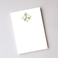 Sara Fitz Holly Cross Stitch Notepad featuring an illustrated cross-stitch design of green holly leaves and red berries at the top with unlined pages.