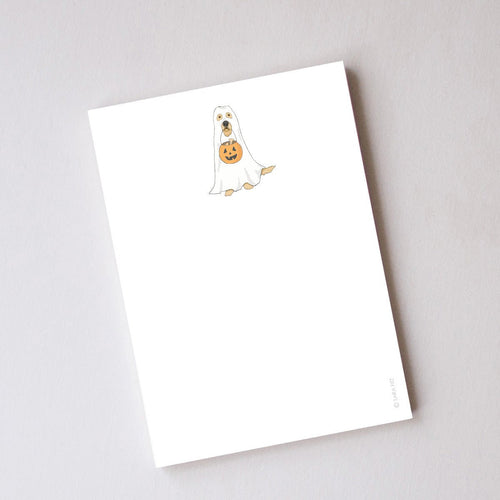Introducing the Trick or Treat Pup Notepad by Sara Fitz—a charming illustrated notepad featuring a delightful dog dressed as a ghost holding a pumpkin-shaped bucket at the top of each page. Made in the USA, this notepad offers unlined pages with ample space for your notes and doodles, while the rest of the sheet remains blank to let your creativity shine.