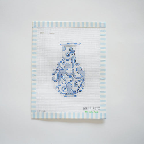 The Octopus Ginger Jar Needlepoint by Sara Fitz features a blue and white ornate vase on 18 mesh canvas, bordered with light blue and white stripes, displayed against a white background.