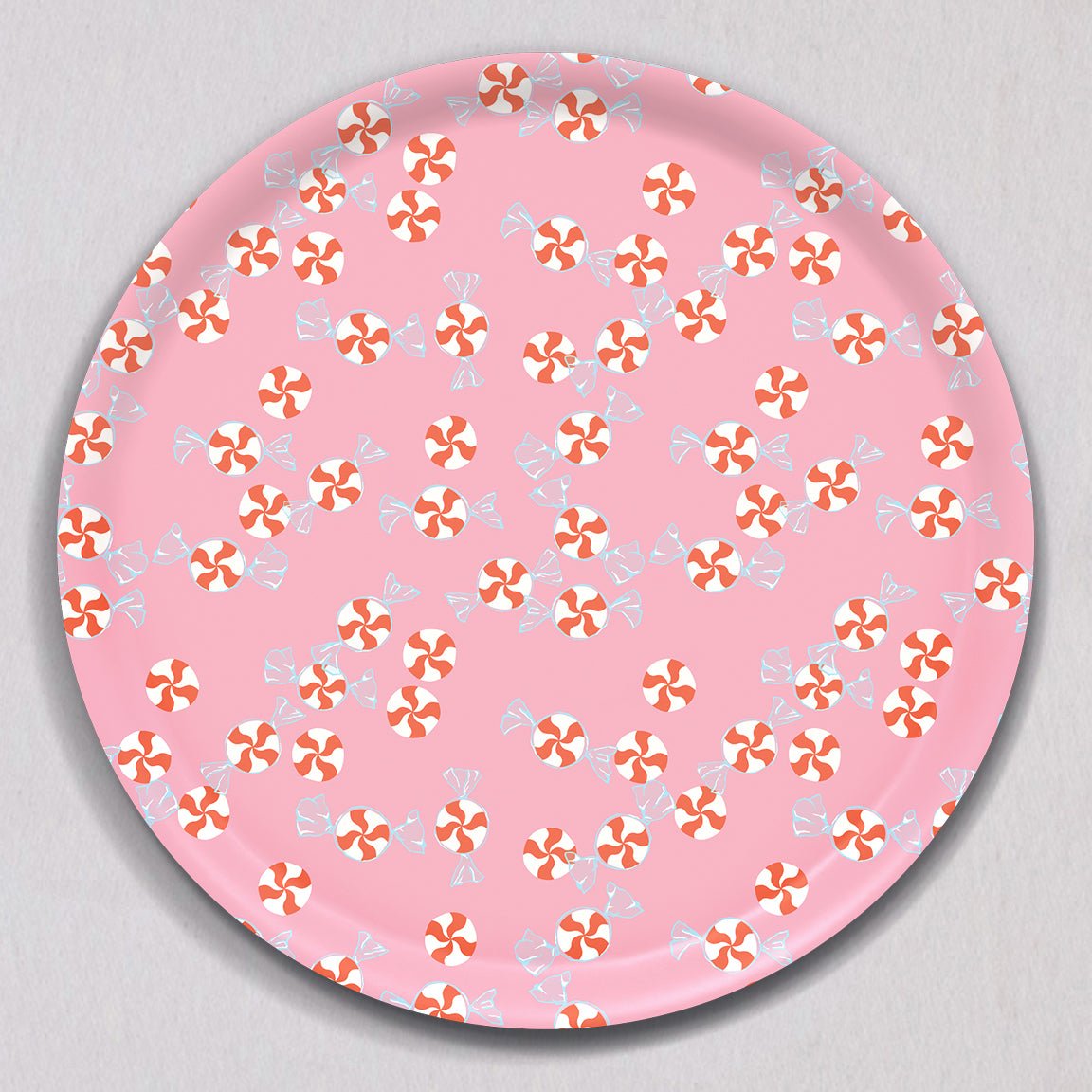 Large Peppermint Candies Tray, Round: a melamine-coated birch wood tray with a pink background patterned with red-and-white peppermint candies and wrapped candy illustrations.