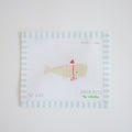 The Santa Whale Needlepoint by Sara Fitz features a beige whale in a red party hat and bowtie on 18 mesh canvas, bordered by blue and white stripes.