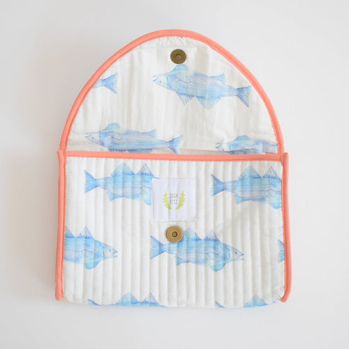 The Sara Fitz Clutch, Blue Fish is a cotton clutch with blue fish illustrations and coral trim, featuring a button closure and shown open on a white background.