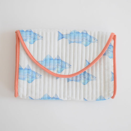 The Sara Fitz Clutch, Blue Fish features a white quilted cotton design with coral pink trim and a repeating blue fish pattern—perfect for adding a playful touch to your accessories collection.