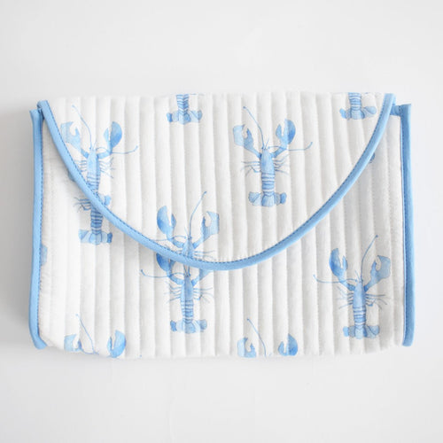 The Sara Fitz Clutch, Blue Lobster is a white quilted cotton clutch with light blue trim, featuring a blue lobster pattern. Handmade in India, it closes with a curved flap.