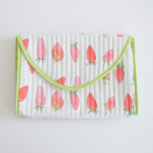 The Sara Fitz Clutch, Strawberry, is a rectangular quilted white cotton clutch with light green trim and an all-over print of pink strawberries with green tops, shown on a white background.
