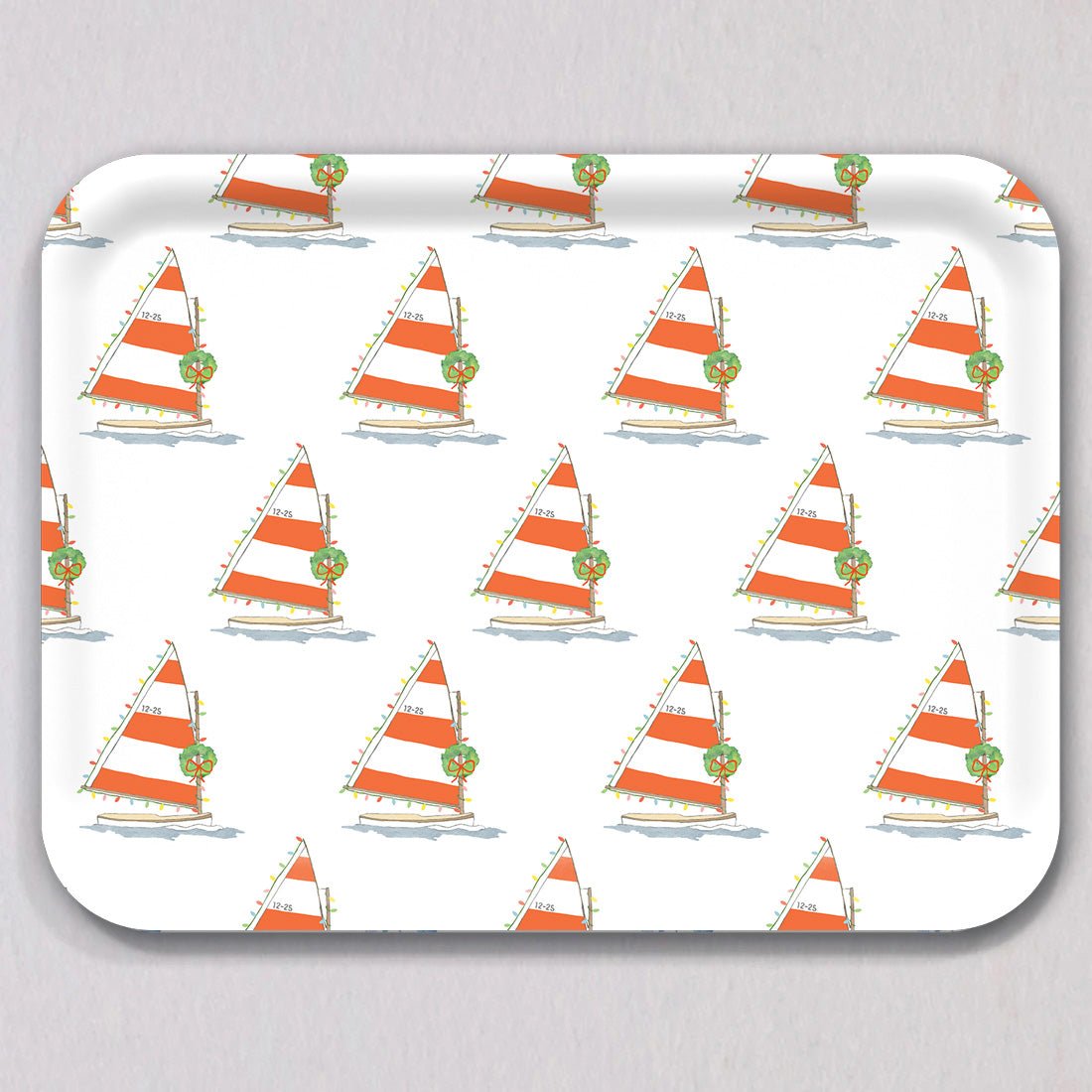 Large Holiday Sailboat Tray: a rectangular melamine coated tray featuring a repeating pattern of sailboats with red-and-white striped sails, decorated with Christmas lights and a wreath, with the text 12-25 on each sail.