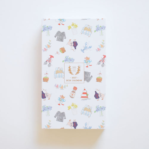 A vertical keepsake box for the 2027 Desk Calendar, featuring a repeating pattern of nautical and floral watercolor illustrations and a center label reading Sara Fitz - 2027 - Desk Calendar.
