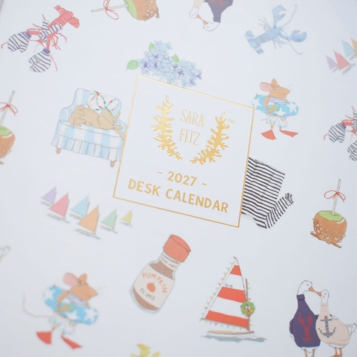 Square 2027 Desk Calendar cover featuring Sara Fitz illustrations of mice, sailboats, lobsters, and candy apples, with the centered text 2027 DESK CALENDAR.