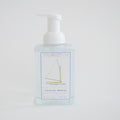 Sara Fitz Foaming Soap Sailboat is a clear pump bottle with a minimalist sailboat design and blue-white label, offering a fresh cotton scent in 16.9 fl oz (500 ml) of non-toxic foaming hand soap.