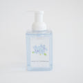 A clear pump bottle labeled Sara Fitz Foaming Soap Hydrangea, filled with light blue foam soap and decorated with blue hydrangea artwork. Non-toxic and inspired by fresh cut hydrangeas.