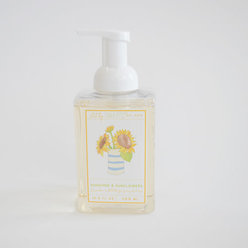 A clear pump bottle of Sara Fitz Foaming Soap Sunflower, 16.9 fl oz (500 ml), with a sunshine scent and a sunflower illustration in a striped vase on the label. Non-toxic liquid hand soap.