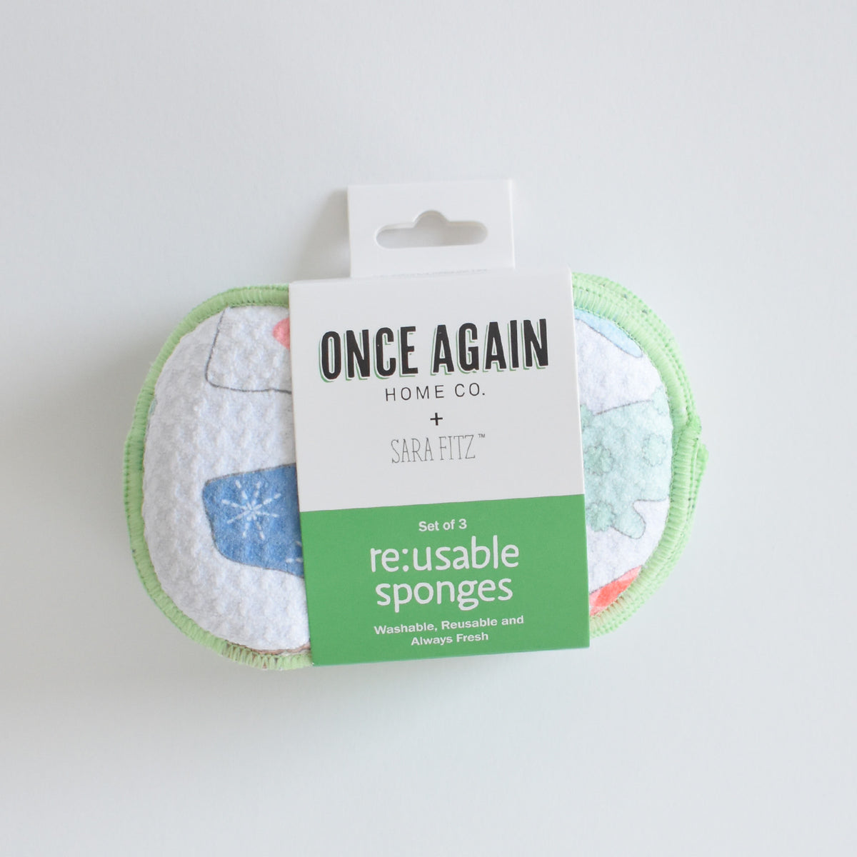 Three patterned, eco-friendly Sara Fitz Re:usable Sponge, Mittens in packaging labeled Once Again Home Co.