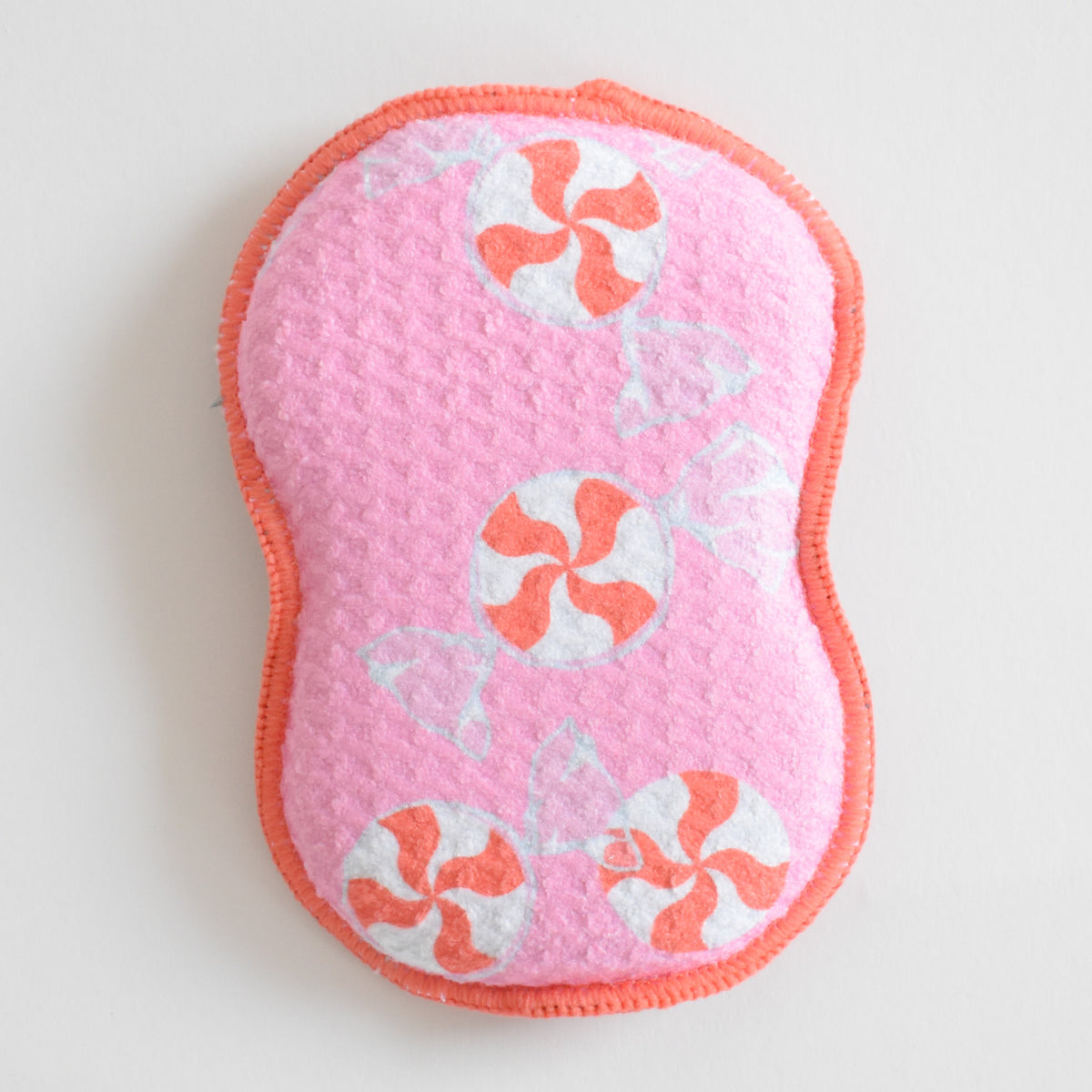 Pink scalloped Re:usable Sponge, Peppermint, decorated with a pattern of peppermint candies.