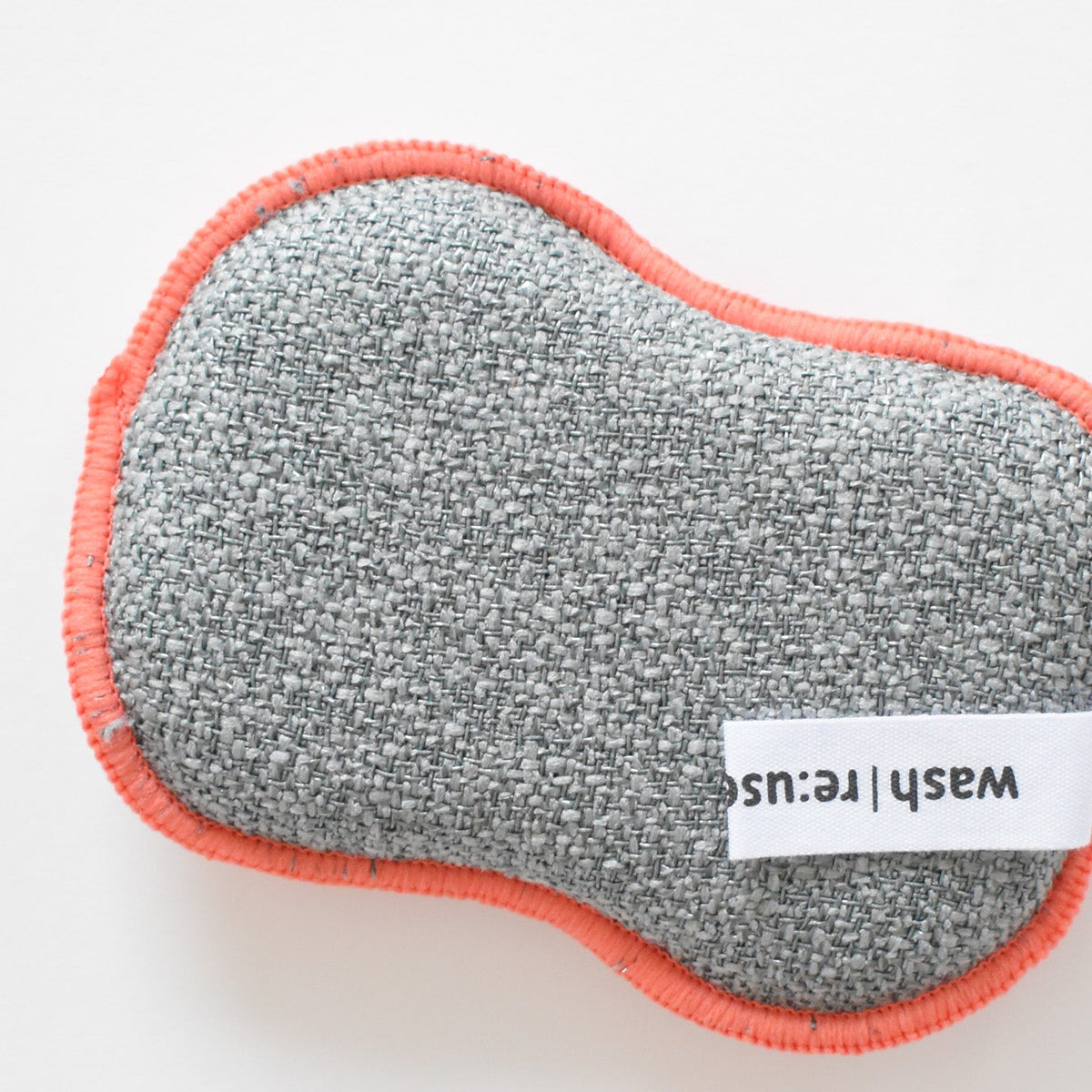 Grey textured Re:usable Sponge, Santa Mug with coral-colored trim and a small white fabric tag that reads wash | re:use.
