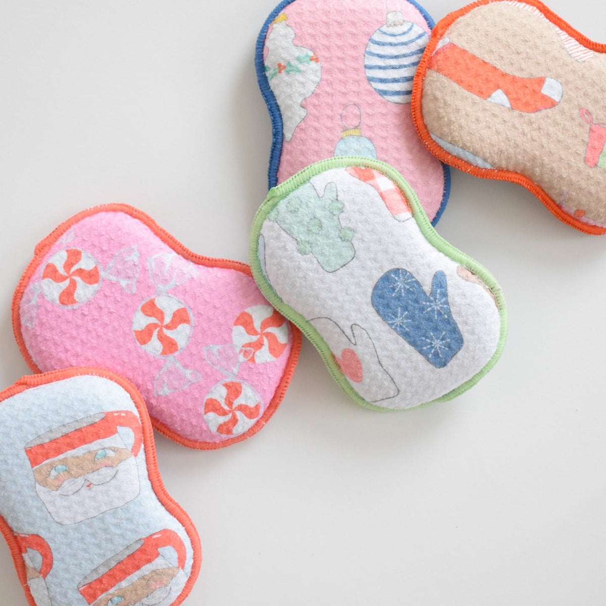 Five Re:usable Sponge, Mittens shaped like peppermint candies, mittens, and Santa Claus.