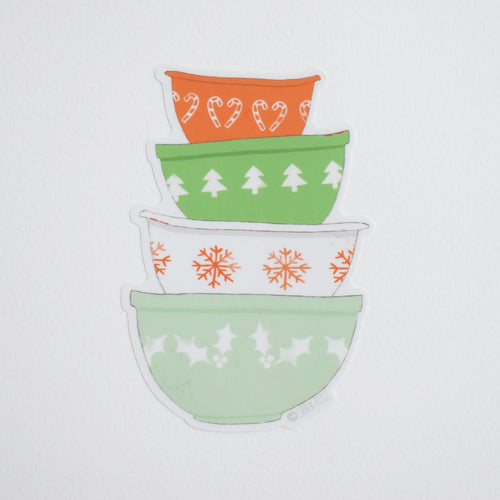 A Sara Fitz Mixing Bowls sticker featuring a stack of four colorful bowls decorated with Christmas patterns including candy canes, pine trees, and snowflakes.