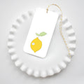 The Sara Fitz Lemon Tags feature a yellow lemon and green leaf illustration on a rectangular white gift tag, attached to yellow and white baker's twine—perfect for adding a cheerful accent to gifts or party favors.