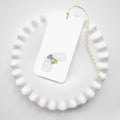 Sara Fitz Bee Tags feature a yellow and black bee illustration on a rectangular white tag with attached yellow-white baker’s twine, displayed on a ruffled plate. Ideal for adding charm to packages, gifts, or favors.