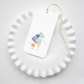 The Sara Fitz Buoy Bunch Tags feature colorful beach umbrellas and accessories. Each white tag is tied with yellow and white baker's twine, adding a playful accent to your gift or table setting.