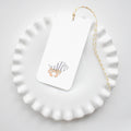 The Sara Fitz Hermit Crab Tags feature a charming hermit crab in a striped shell on a white tag with yellow and white baker’s twine, making them perfect for unique gift tags or place settings.