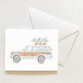 The Seersucker Wagon Note Card by Sara Fitz features a vintage wood-paneled station wagon with potted flowers on its roof, printed in the USA and presented on a white envelope against a light background.