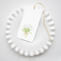 The Sara Fitz Tulips Tags feature an illustration of white tulips tied with a pink ribbon and come with yellow and white baker's twine, perfect for adding a charming touch to your gifts.