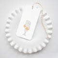 The Sara Fitz Whale Tags feature a gray whale in an orange life ring on a rectangular tag, finished with yellow-and-white baker's twine for easy tying—a charming choice for gift wrapping.